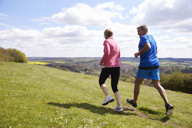 Rear View Of Mature Couple Jogging In Countryside